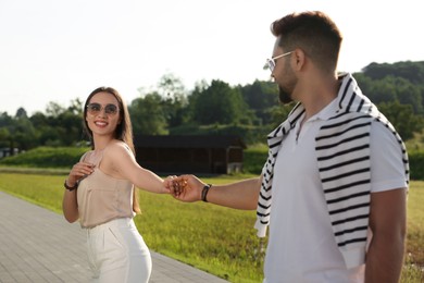 Romantic date. Beautiful couple walking in park on sunny day