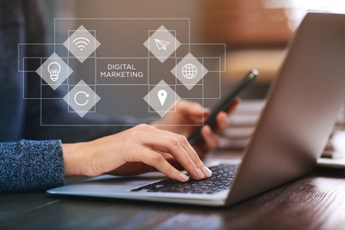 Image of Businesswoman with smartphone working on laptop indoors, closeup. Digital marketing