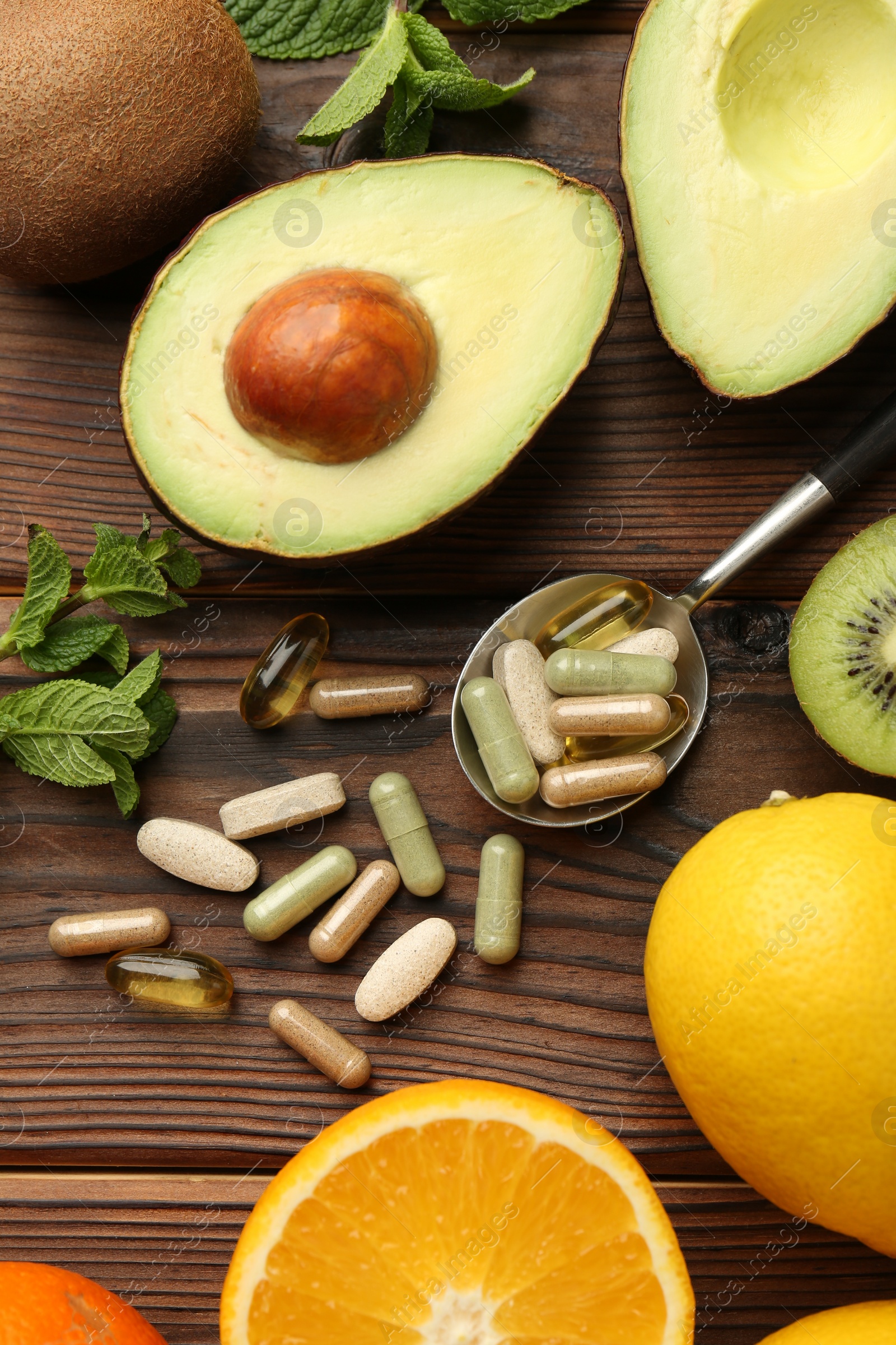 Photo of Different vitamin pills and fresh fruits on wooden table, flat lay