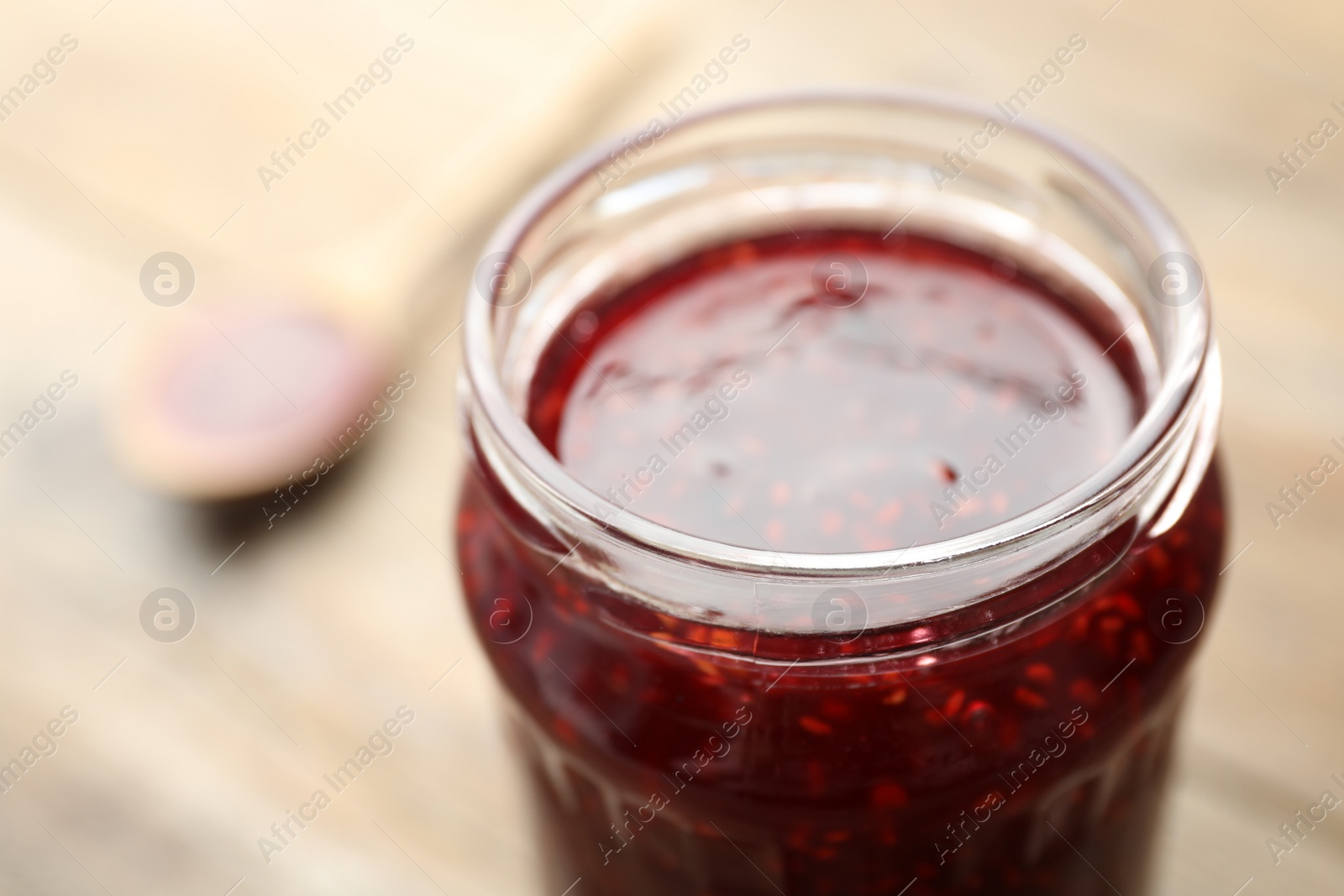 Photo of Homemade delicious raspberry jam on table, closeup