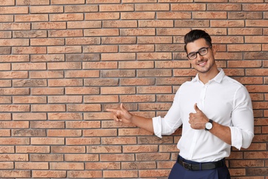 Photo of Portrait of handsome young man and space for text on brick wall background