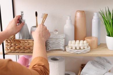 Photo of Bath accessories. Woman organizing personal care products indoors, closeup