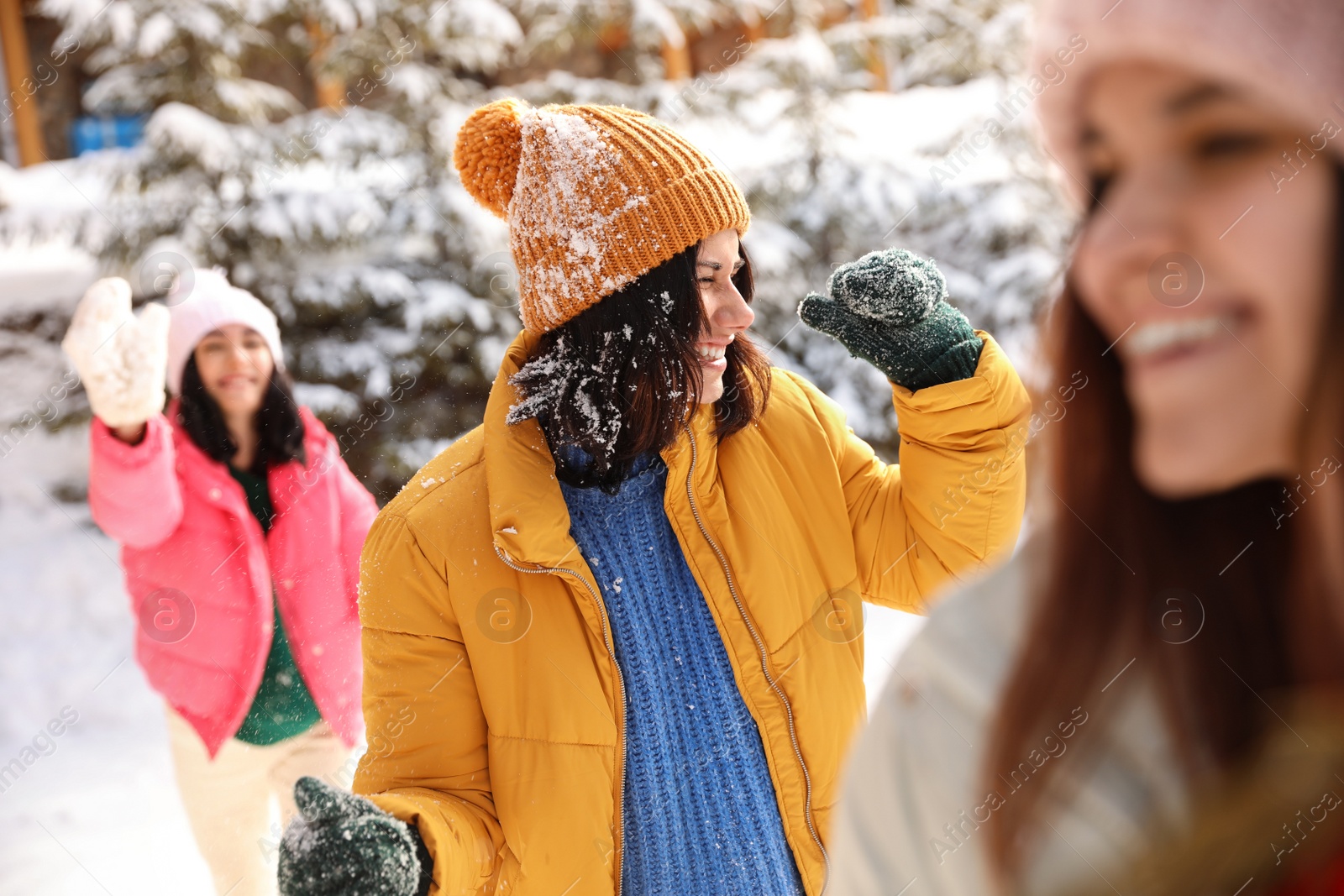 Photo of Group of friends playing snowballs outdoors. Winter vacation