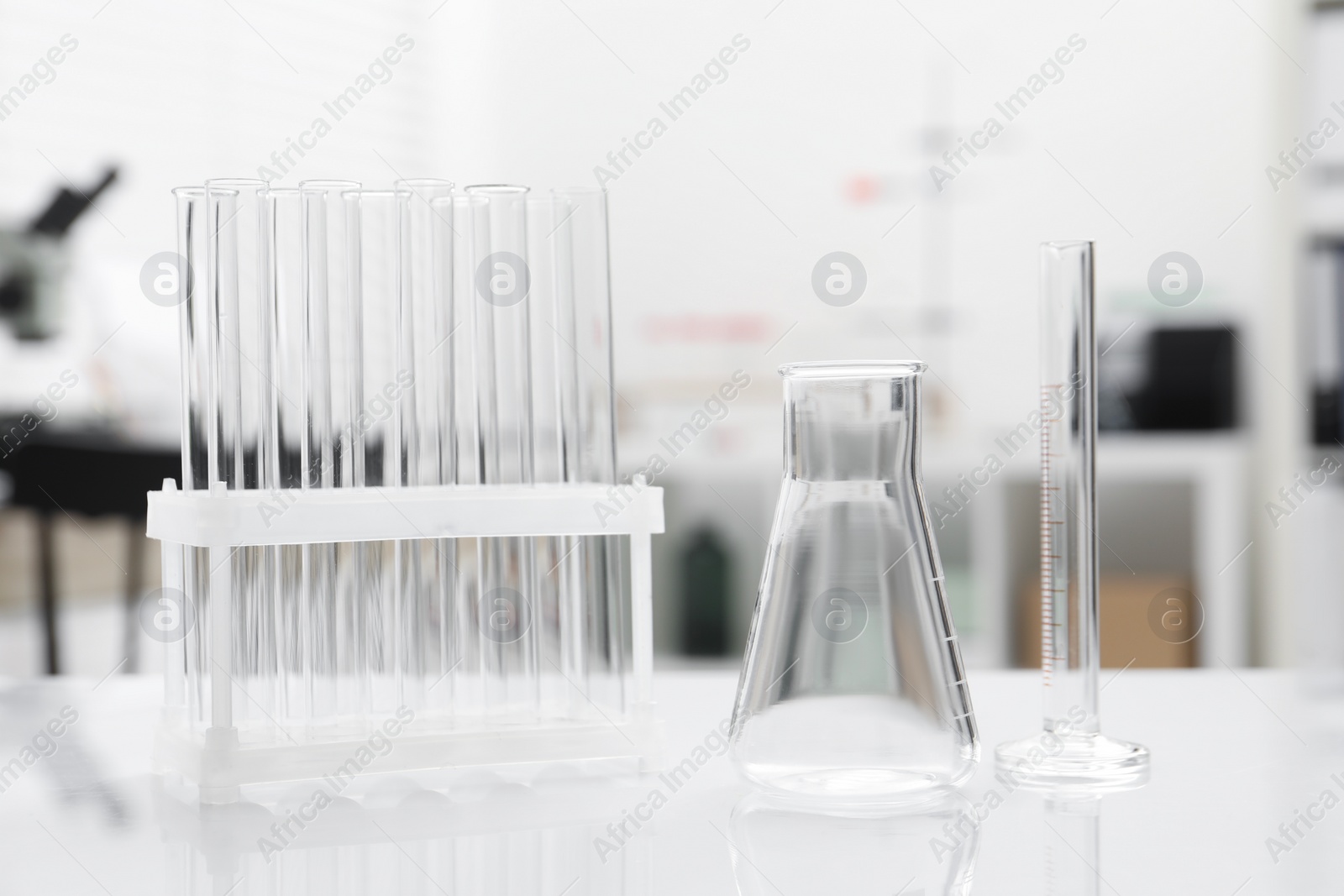 Photo of Laboratory analysis. Flask and test tubes on white table indoors