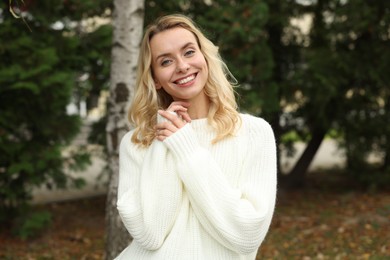Photo of Happy woman in stylish warm sweater outdoors
