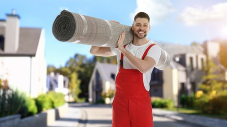 Image of Worker with rolled carpet outdoors on sunny day. Banner design