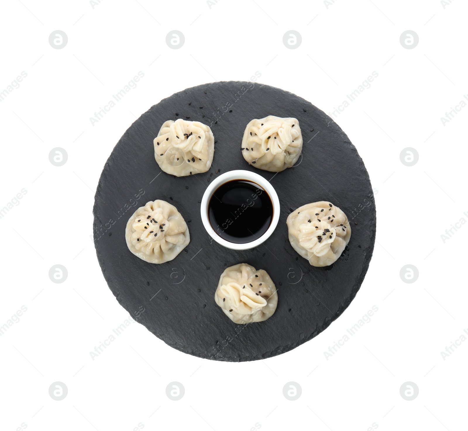 Photo of Slate plate with tasty baozi dumplings and soy sauce on white background, top view