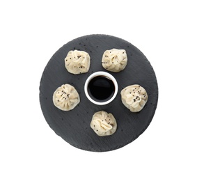 Photo of Slate plate with tasty baozi dumplings and soy sauce on white background, top view