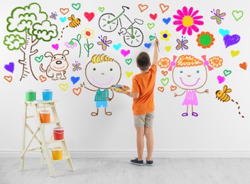 Image of Cute child boy drawing of colorful dye many different picture on white wall
