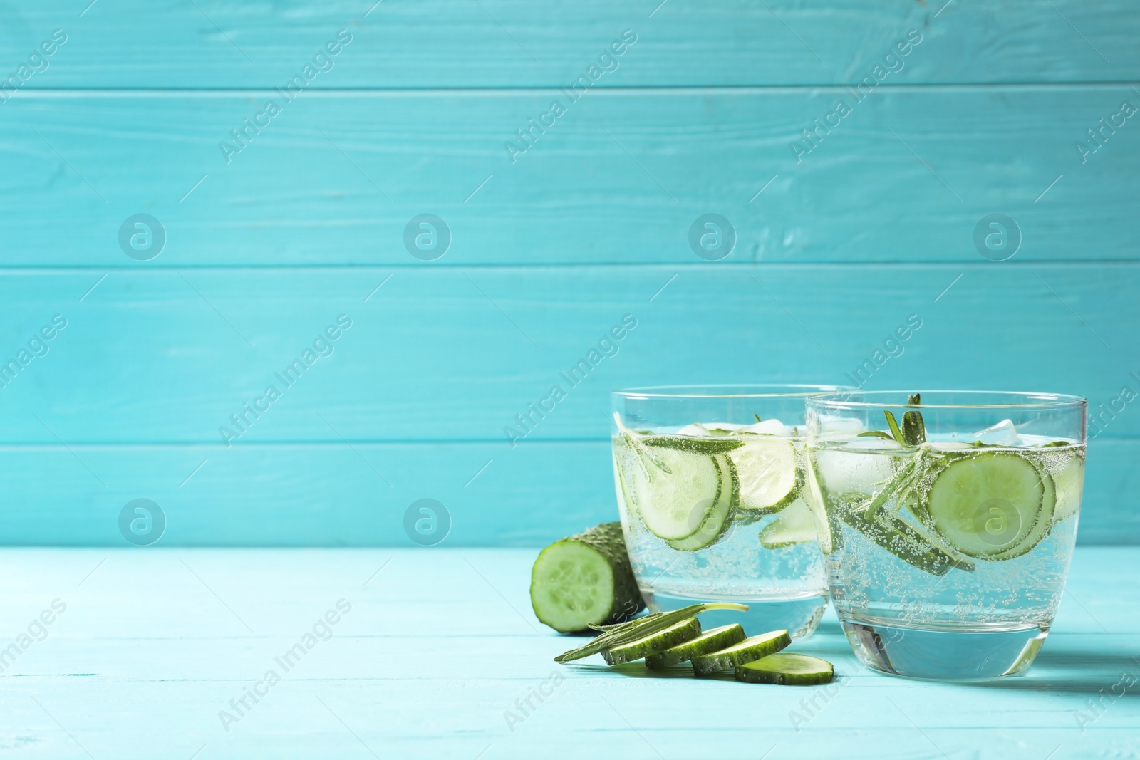 Photo of Natural lemonade with cucumber in glasses on wooden table