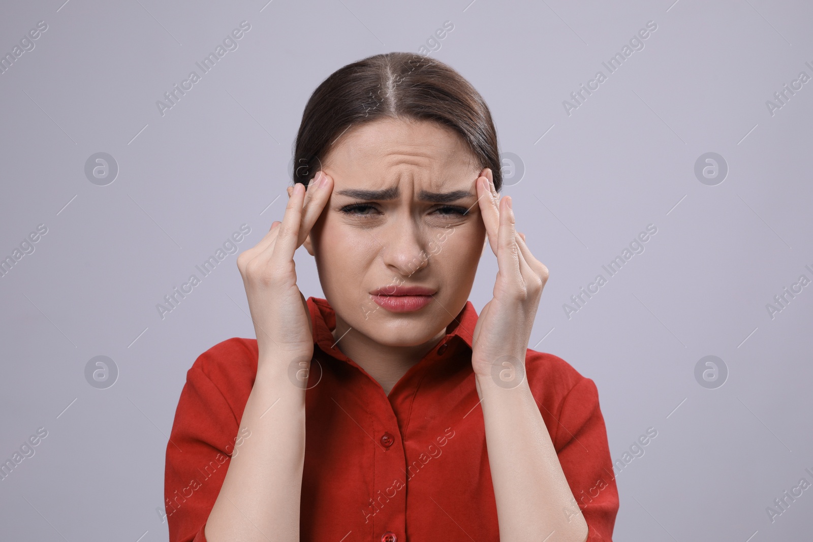 Photo of Woman suffering from headache on light grey background. Cold symptoms