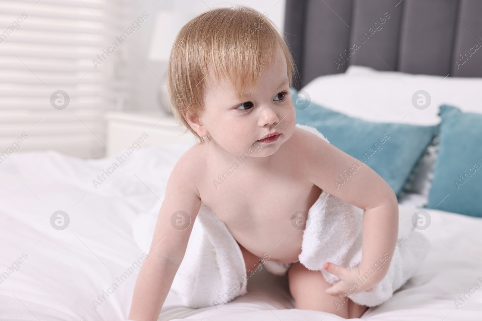 Photo of Cute little baby with towel after bathing on bed