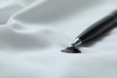 Photo of Pen and stain of black ink on white shirt, closeup. Space for text