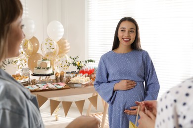 Photo of Happy pregnant woman and her friends at baby shower party