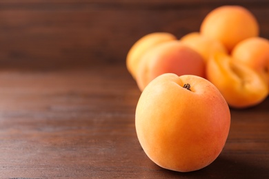 Delicious ripe sweet apricot on wooden table, closeup. Space for text