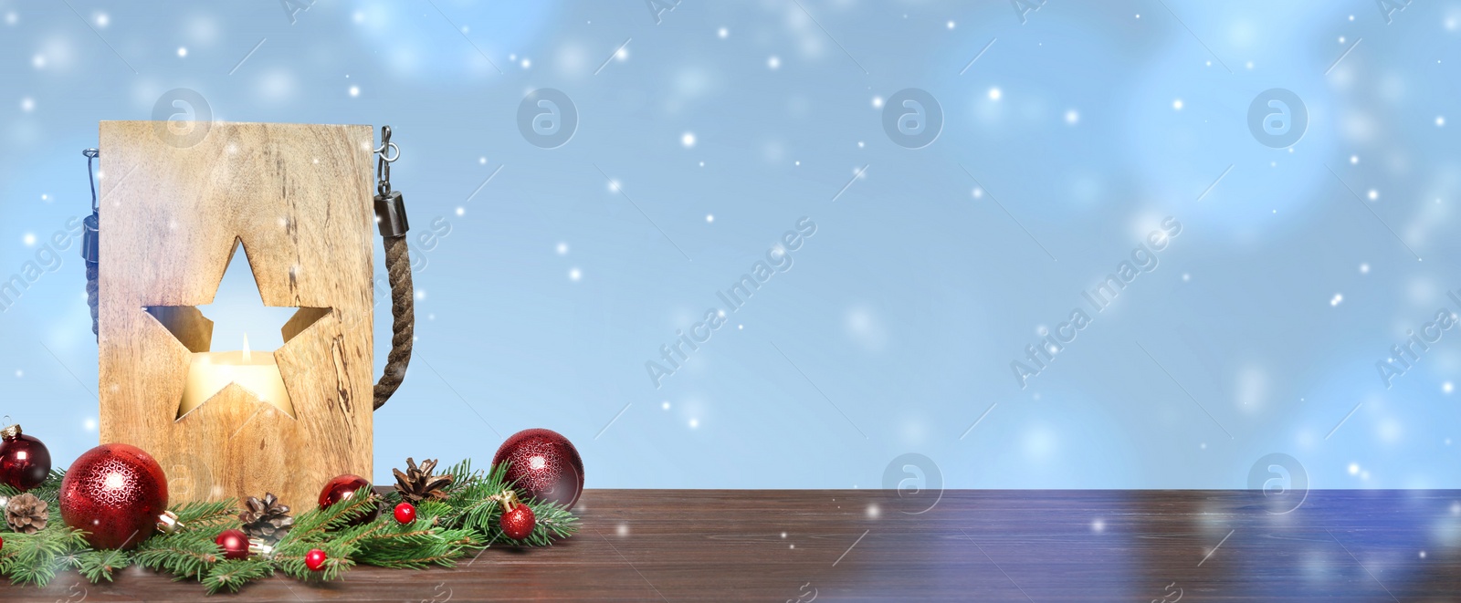 Image of Wooden Christmas lantern with burning candle and decor on table, space for text. Banner design 