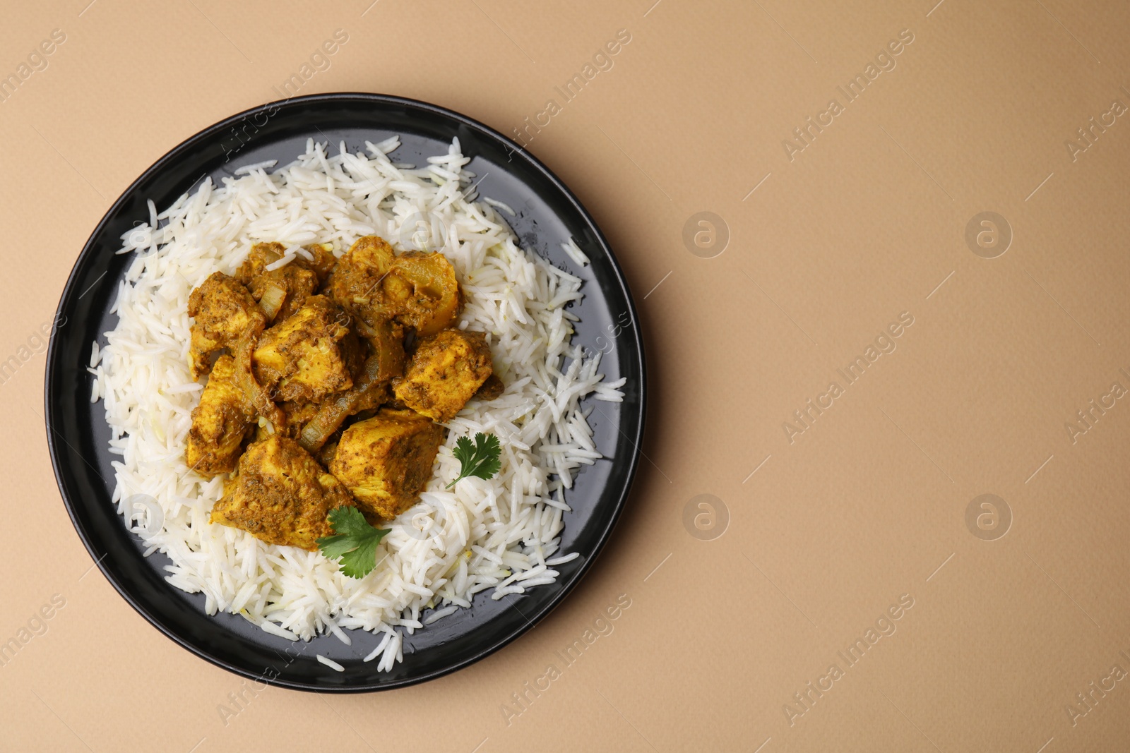 Photo of Delicious chicken curry with rice on beige background, top view. Space for text