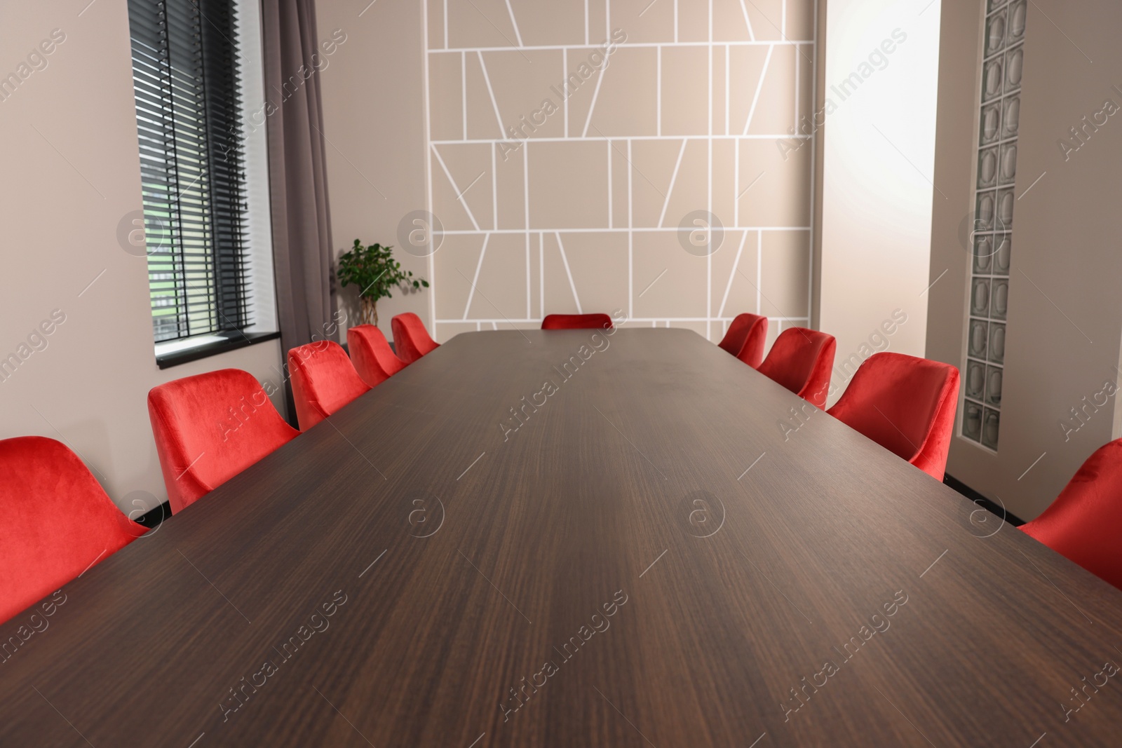 Photo of Empty conference room with stylish red office chairs and large wooden table