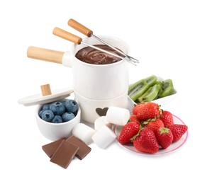 Photo of Fondue pot with melted chocolate, fresh berries, kiwi, marshmallows and forks isolated on white