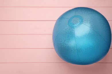 Photo of Light blue beach ball on pink wooden background, top view. Space for text