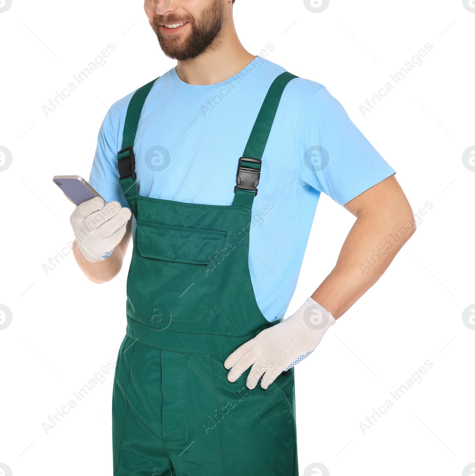 Photo of Professional repairman in uniform with smartphone on white background, closeup