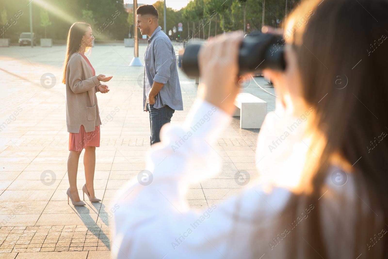 Photo of Jealous ex girlfriend with binoculars spying on couple outdoors, closeup