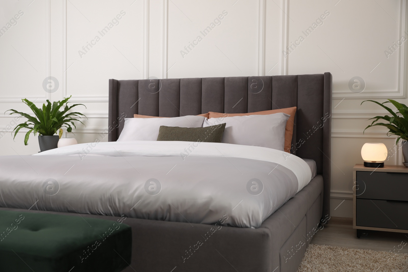 Photo of Comfortable bed with pillows and bedding in stylish room. Interior design