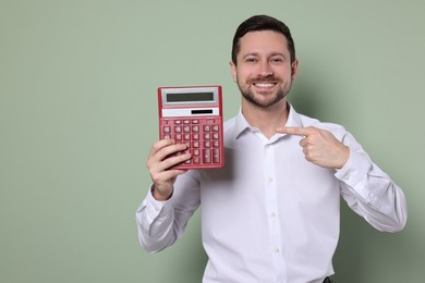 Photo of Happy accountant showing calculator on olive background. Space for text