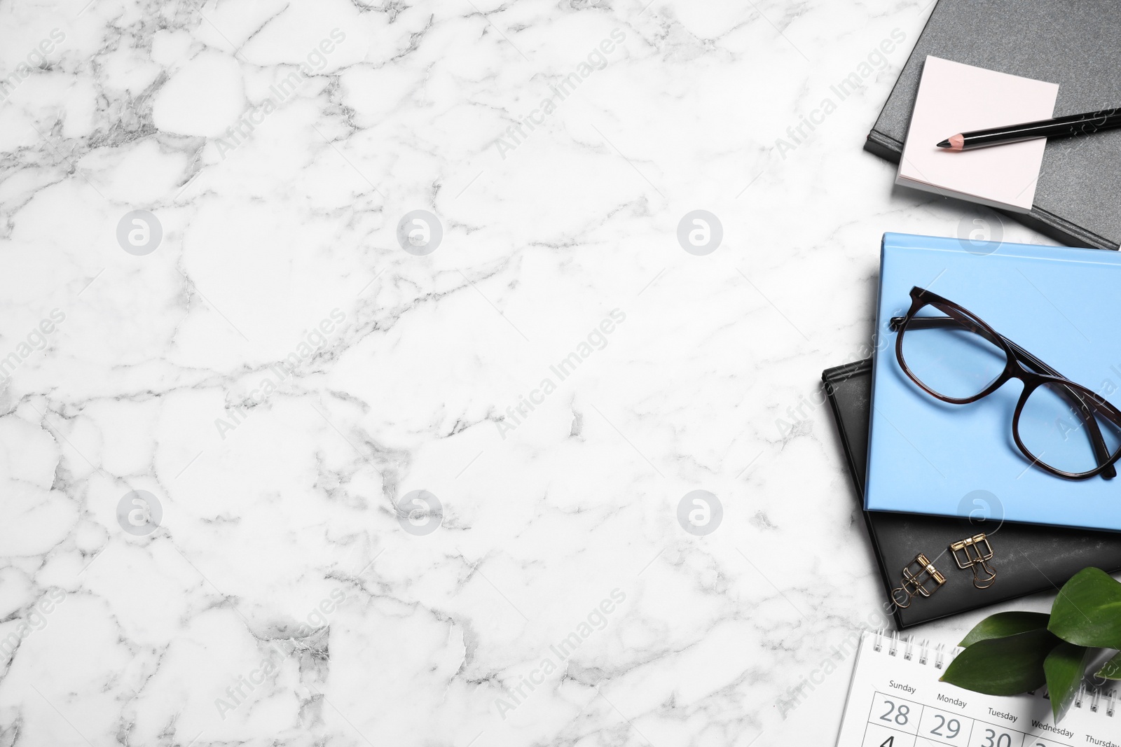 Photo of Flat lay composition with stationery on white marble table, space for text