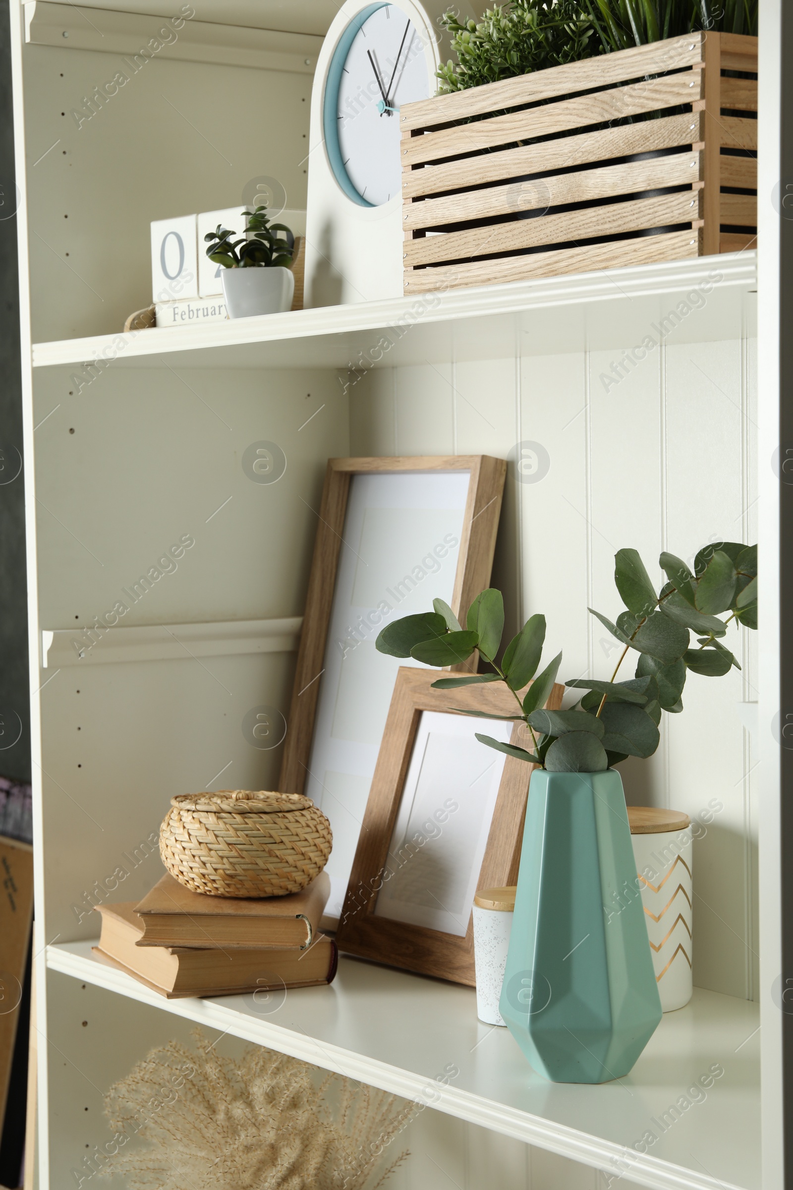 Photo of White shelving unit with different decorative elements