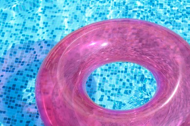 Photo of Inflatable ring floating on water in swimming pool, closeup