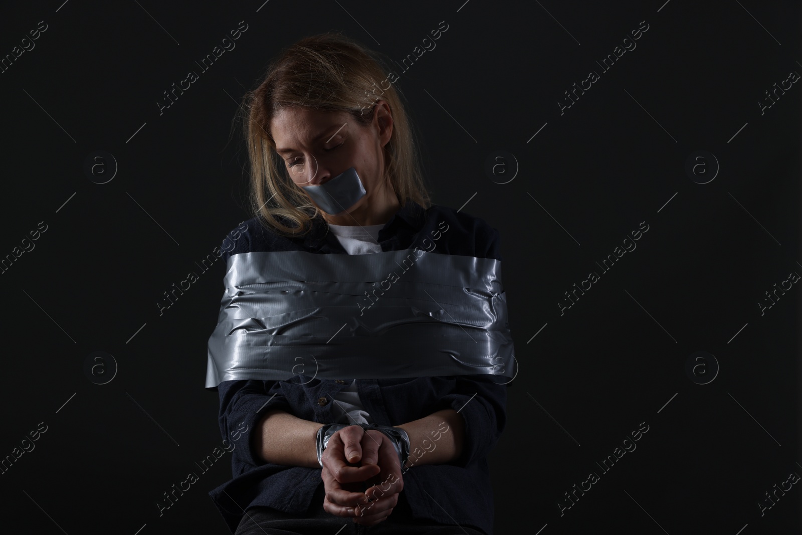 Photo of Woman taped up and taken hostage on dark background