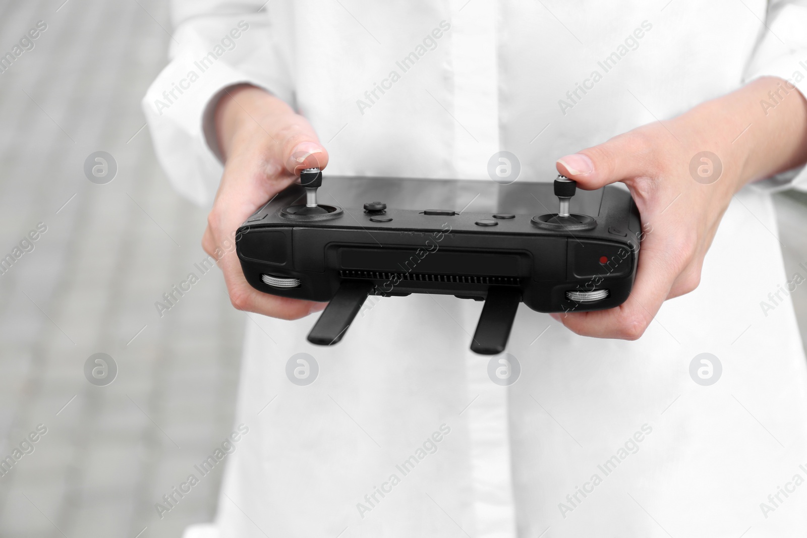 Photo of Woman with modern drone controller outdoors, closeup