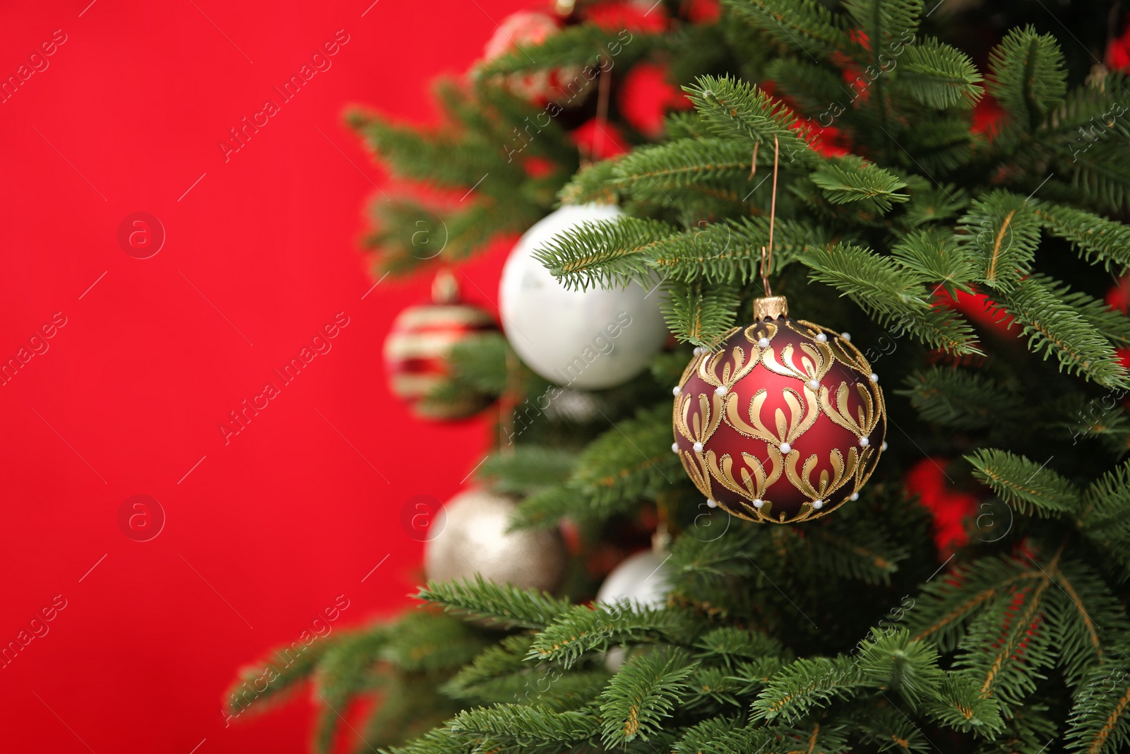 Photo of Beautifully decorated Christmas tree against color background, closeup