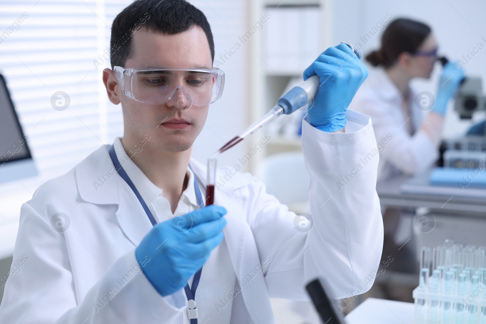 Photo of Scientist dripping sample into test tube in laboratory