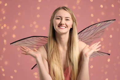 Photo of Beautiful girl in fairy costume with wings on pink background