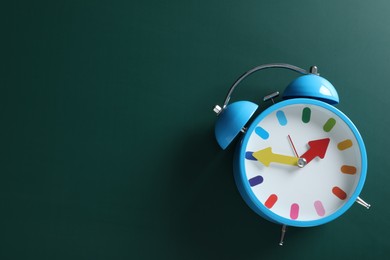 Alarm clock and space for text on green background, top view. School time