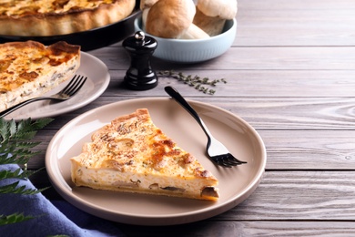 Photo of Delicious pie with mushrooms and cheese served on wooden table