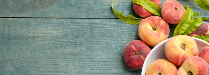 Fresh flat peaches on turquoise wooden table, top view. Banner design with space for text