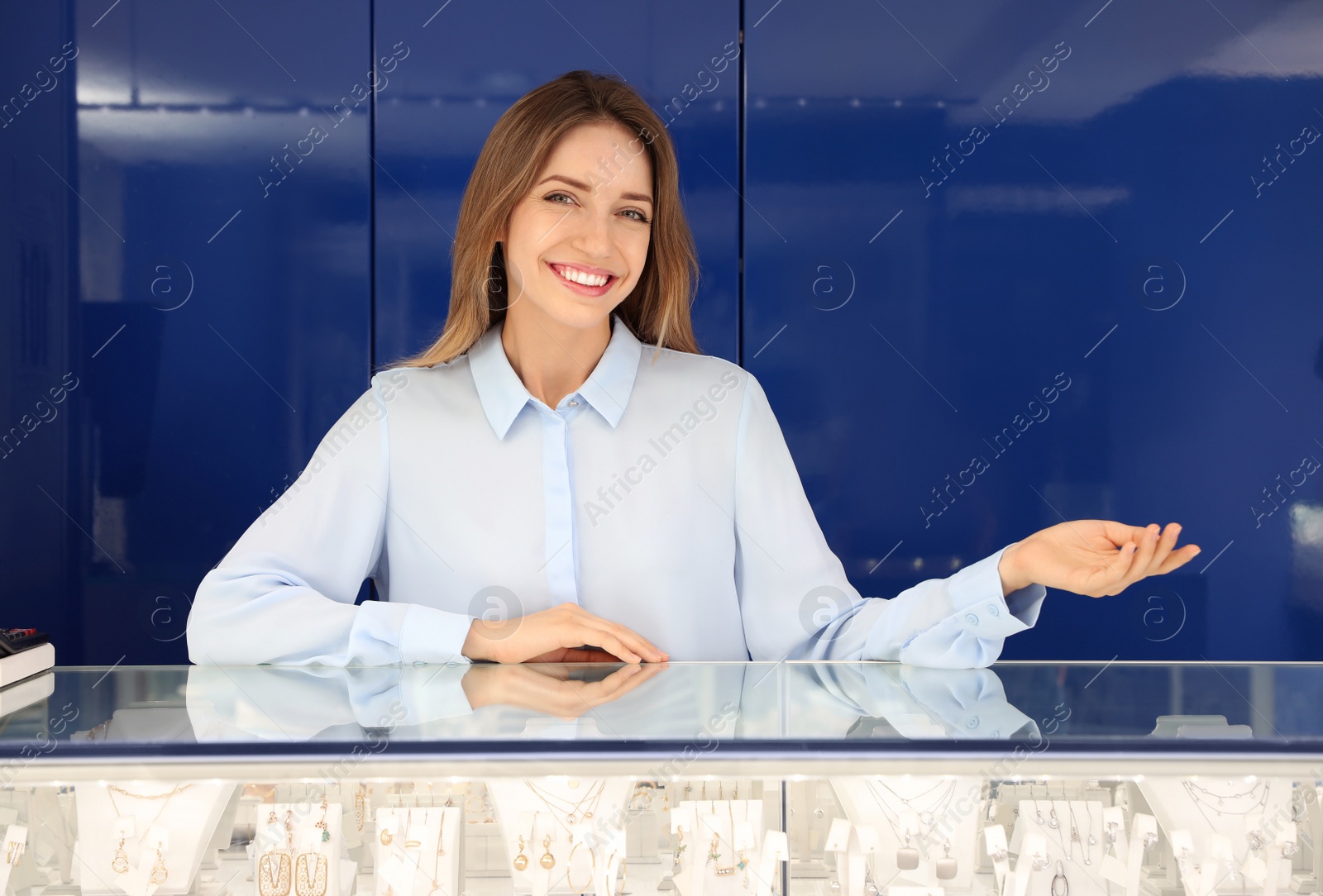 Photo of Portrait of young saleswoman near showcase in jewelry store