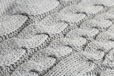 Photo of Grey knitted fabric with beautiful pattern as background, closeup