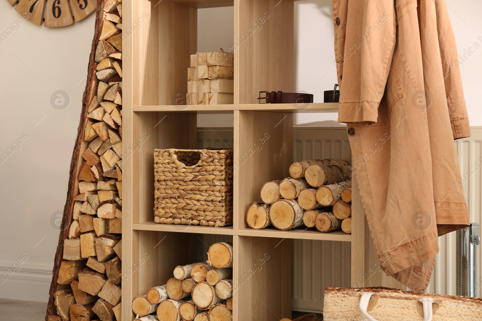 Photo of Shelving unit with firewood indoors. Interior design