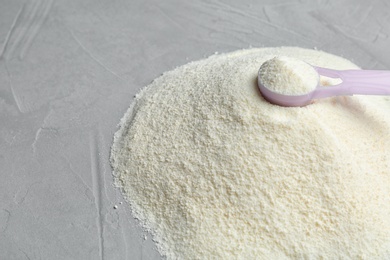 Photo of Pile of protein powder, scoop and space for text on grey background, closeup. Preparing shake