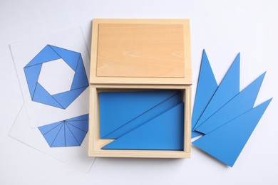 Photo of Set of geometrical figures in box on white background, top view. Montessori toy