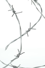 Photo of Shiny metal barbed wire isolated on white