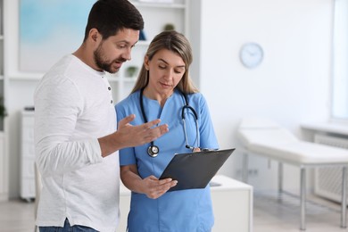 Photo of Professional doctor working with patient in hospital, space for text