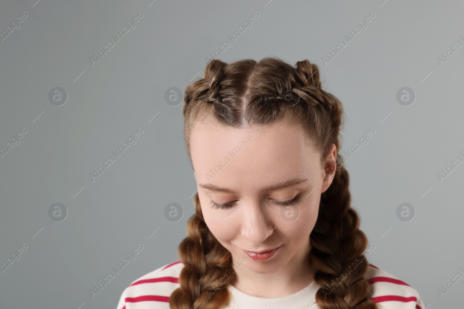 Photo of Woman with braided hair on grey background