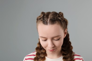 Woman with braided hair on grey background