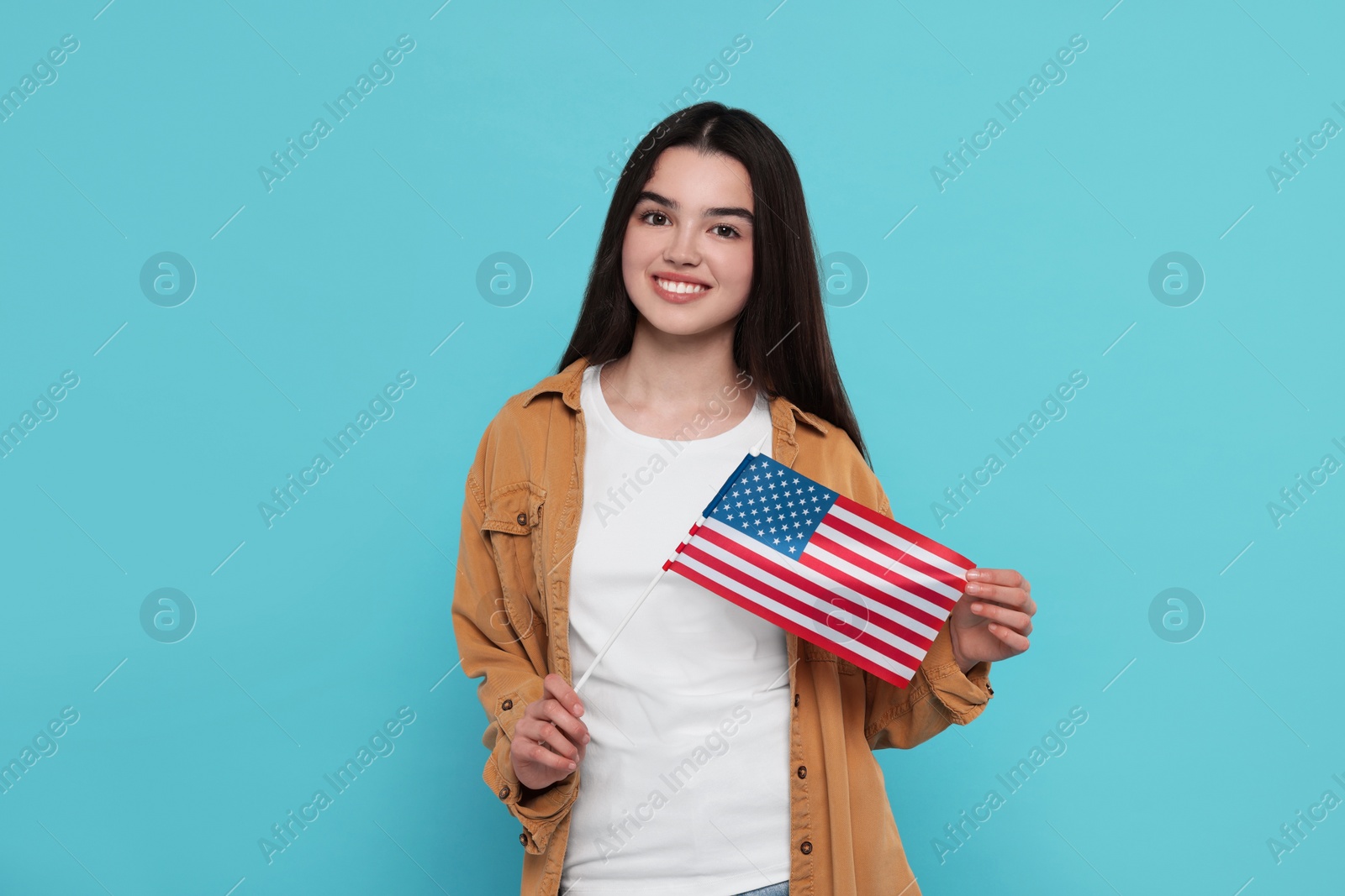 Photo of 4th of July - Independence Day of USA. Happy girl with American flag on light blue background