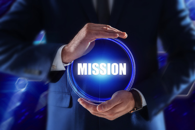 Mission concept. Businessman demonstrating word on blurred background